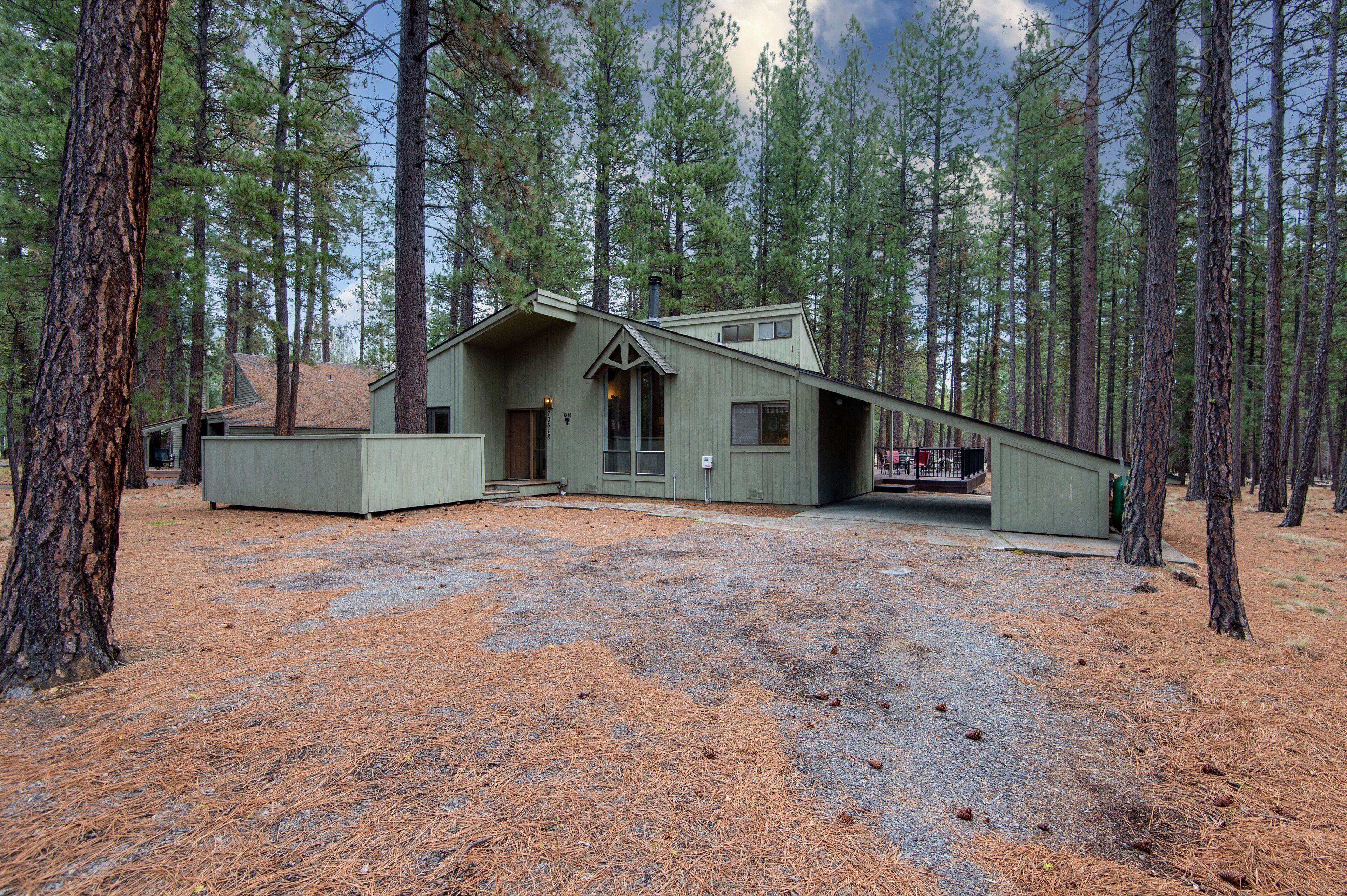 A cabin with a sloped roof, a chimney, and a large window.