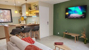 A modern living room with a sofa, a coffee table, and a TV mounted on the wall.