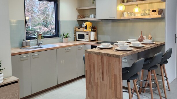 A modern kitchen with a central island, built-in cabinets, and pendant lighting.