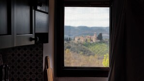 Una ventana con vistas a un paisaje, que incluye un edificio y árboles.