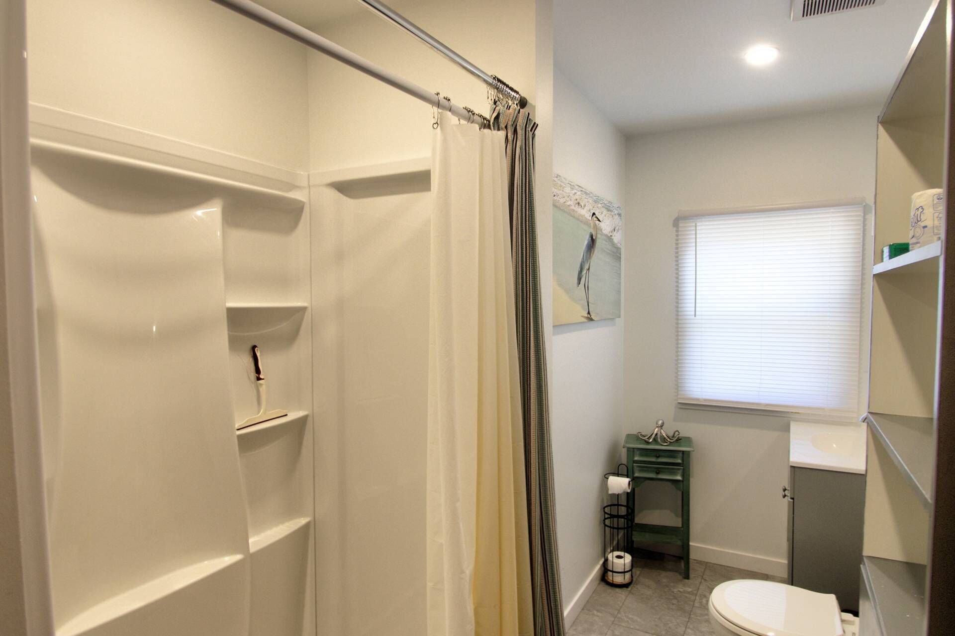 Une salle de bain avec douche, toilettes et lavabo.