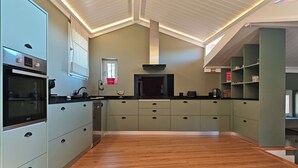 Eine moderne Küche mit Einbauofen, Kaffeemaschine und Fenster mit Blick.