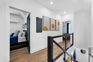 Upstairs hallway with modern railing and access to bedrooms. - The Sports Hub | Modern Stay for Sports Fans (Fayetteville)