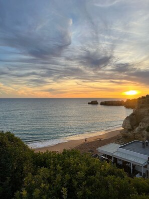 A coastal view with a beach, rocky cliffs, and a building with a roof overlooking the sea. - Vila Algarvve II-5 mn walking from Beach-heated pool-see view-16 pax (Albufeira)