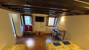 A room with two beds, a desk, a chair, and a TV mounted on the wall. - Luky lovely place in the very heart of central Venice (Venezia)