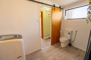 Ein kleines Badezimmer mit Toilette, Duschkabine und Waschmaschine.