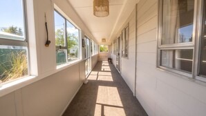 En lång, smal hall med stora fönster på båda sidor, vilket släpper in naturligt ljus.