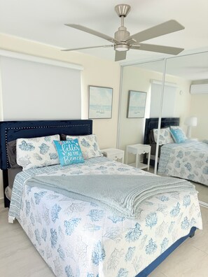 A bedroom with a bed, a ceiling fan, a mirror, and artwork on the wall. - Sun Beach Escape – Vacation Rental in Boquerón, Cabo Rojo (Boquerón)