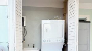 A compact laundry room with a washing machine, a sink, and a small storage cabinet. - Sun Beach Escape – Vacation Rental in Boquerón, Cabo Rojo (Boquerón)