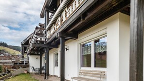 A building with a wooden exterior, a bench outside, and a sign above the entrance.