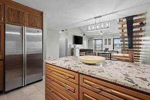Una cocina moderna con electrodomésticos de acero inoxidable, armarios de madera y una isla grande con un bol.