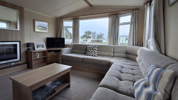 A modern living room with a sofa, TV, and wooden coffee table. - Glasyln 37 (Porthmadog)