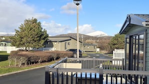 A residential area with a modern house, a street lamp, and a mountain in the background. - Glasyln 37 (Porthmadog)