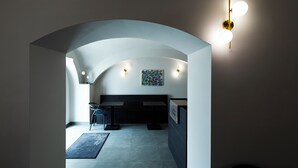 A modern interior with a curved ceiling, a seating area, and wall-mounted lighting.