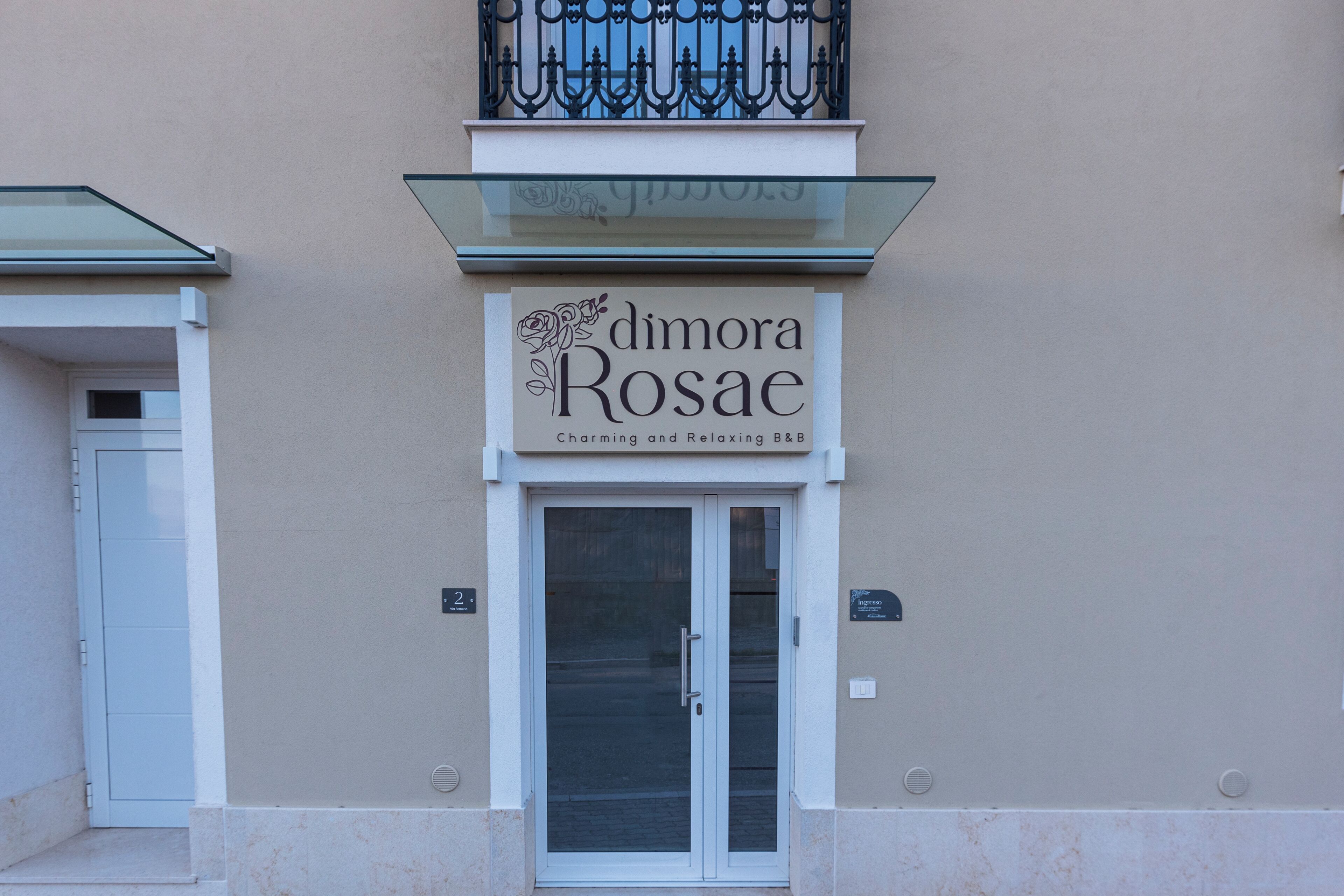 A building facade with a sign for 'dimora Rosae' indicating a B&B.
