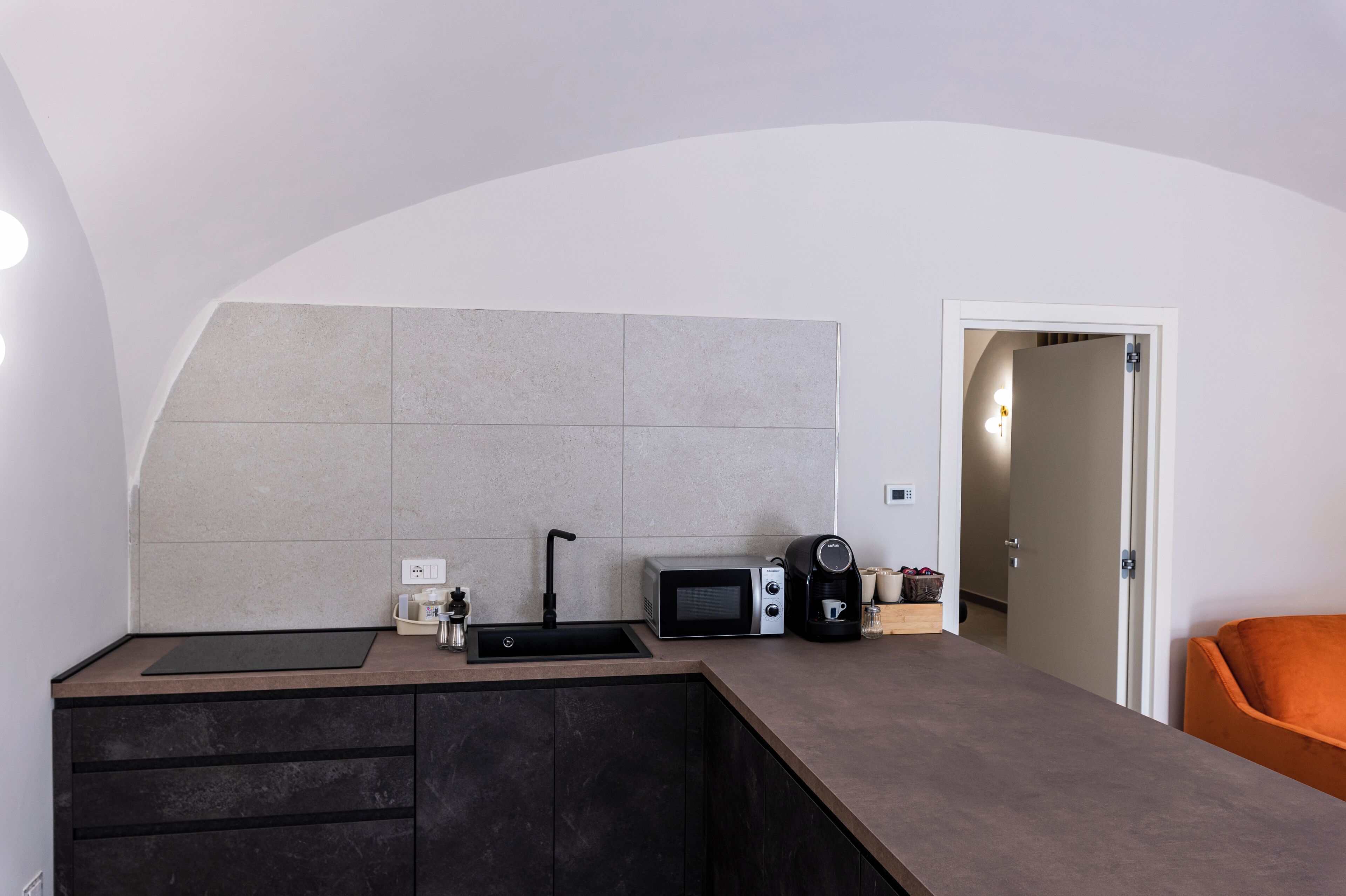 Una cocina compacta con un lavaplatos, un microondas y una cafetera.