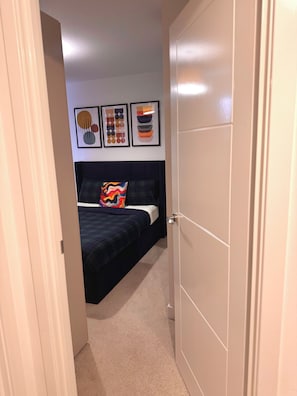A bedroom with a bed, a door, and wall art. - Room-room in Blackburn - Peters Place (Blackburn)