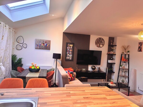 A modern living room with a dining area, a flat-screen TV, and a skylight. - Room-room in Blackburn - Peters Place (Blackburn)