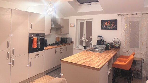 A modern kitchen with a central island, built-in appliances, and a skylight. - Room-room in Blackburn - Peters Place (Blackburn)
