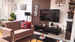 A modern living room with a sofa, coffee table, TV, and decorative items. - Room-room in Blackburn - Peters Place (Blackburn)