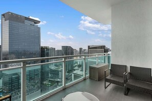 A balcony with a city view, a wicker sofa, and a small table. - 47th-Floor Brickell Condo w/ City Views & Pool (Miami)