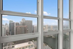 A high-rise building with multiple windows, a clear sky, and a view of other buildings and a river. - 47th-Floor Brickell Condo w/ City Views & Pool (Miami)