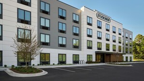 Een meerhoog hotel met een modern ontwerp, met een opvallend 'STUDIOS' bord op de gevel.