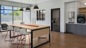 Une cuisine moderne équipée d’une machine à café intégrée, d’un réfrigérateur et d’un four à micro-ondes.