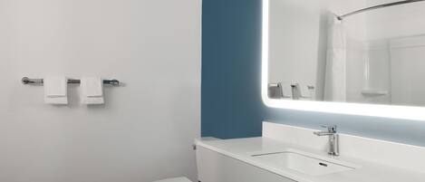 A modern bathroom with a white toilet, a sink with a mirror, and a towel rack.