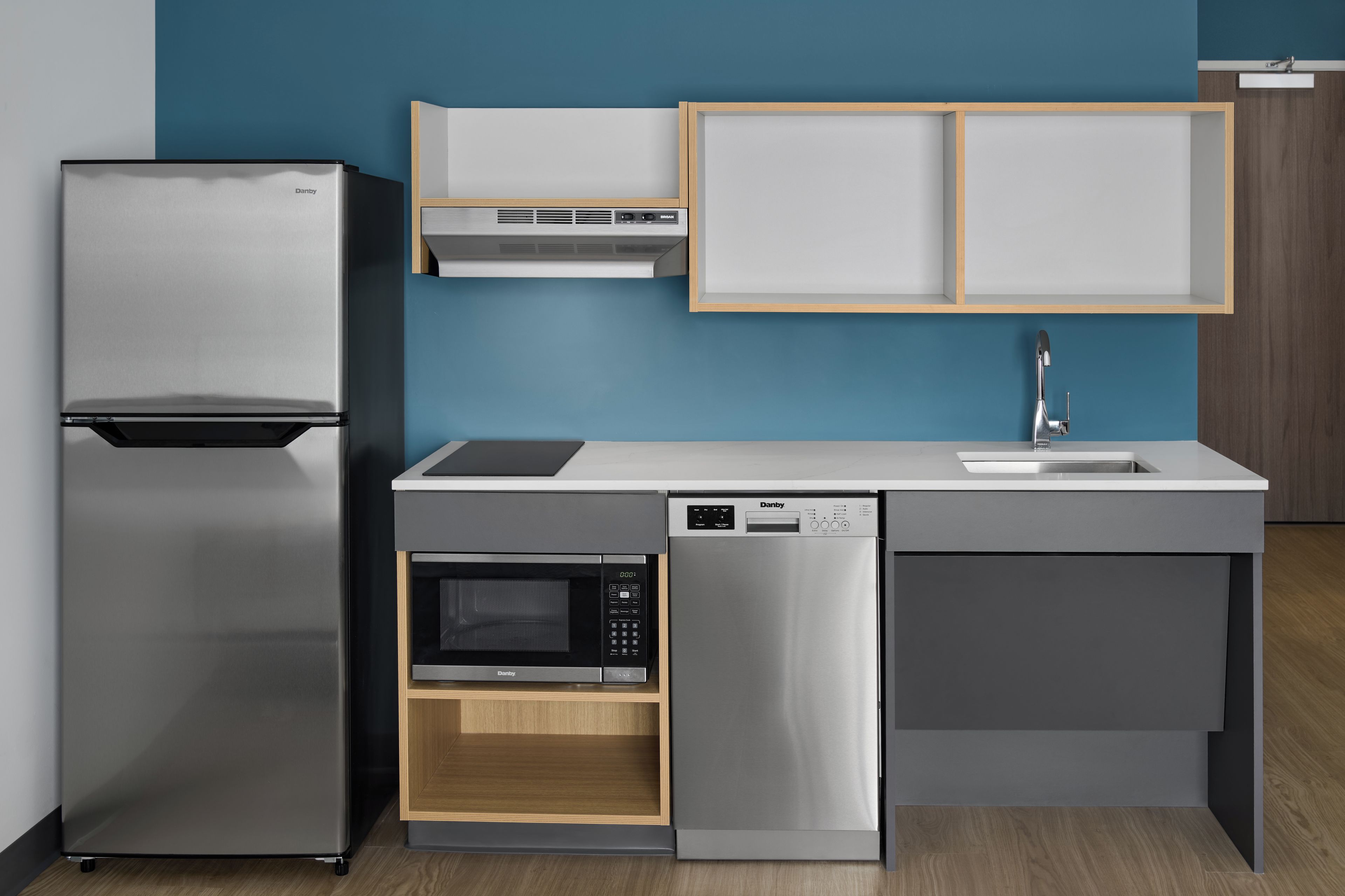 Eine moderne Küche mit integriertem Kühlschrank, Mikrowelle und Geschirrspüler.
