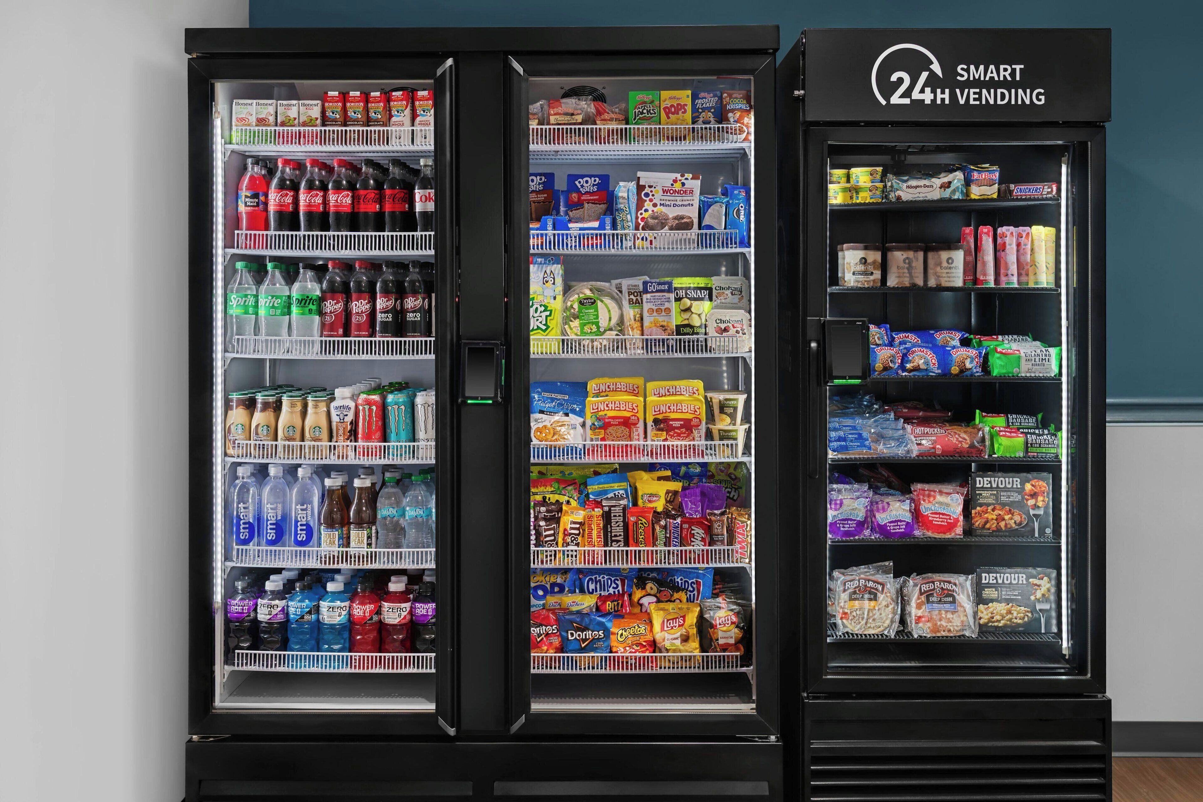 A vending machine with a 24-hour service sign, stocked with beverages and snacks.