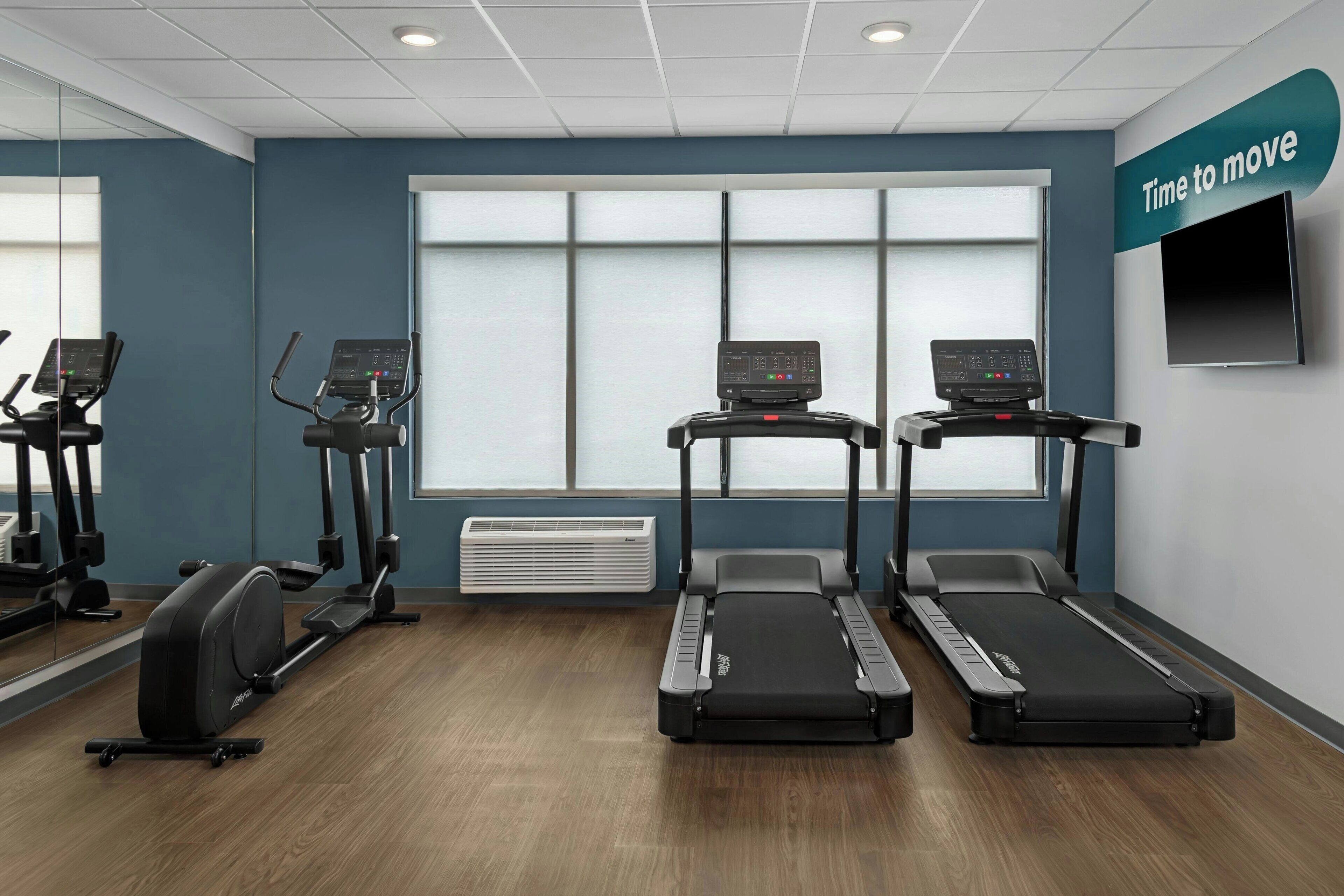 A gym with treadmills, an elliptical, and a stationary bike.