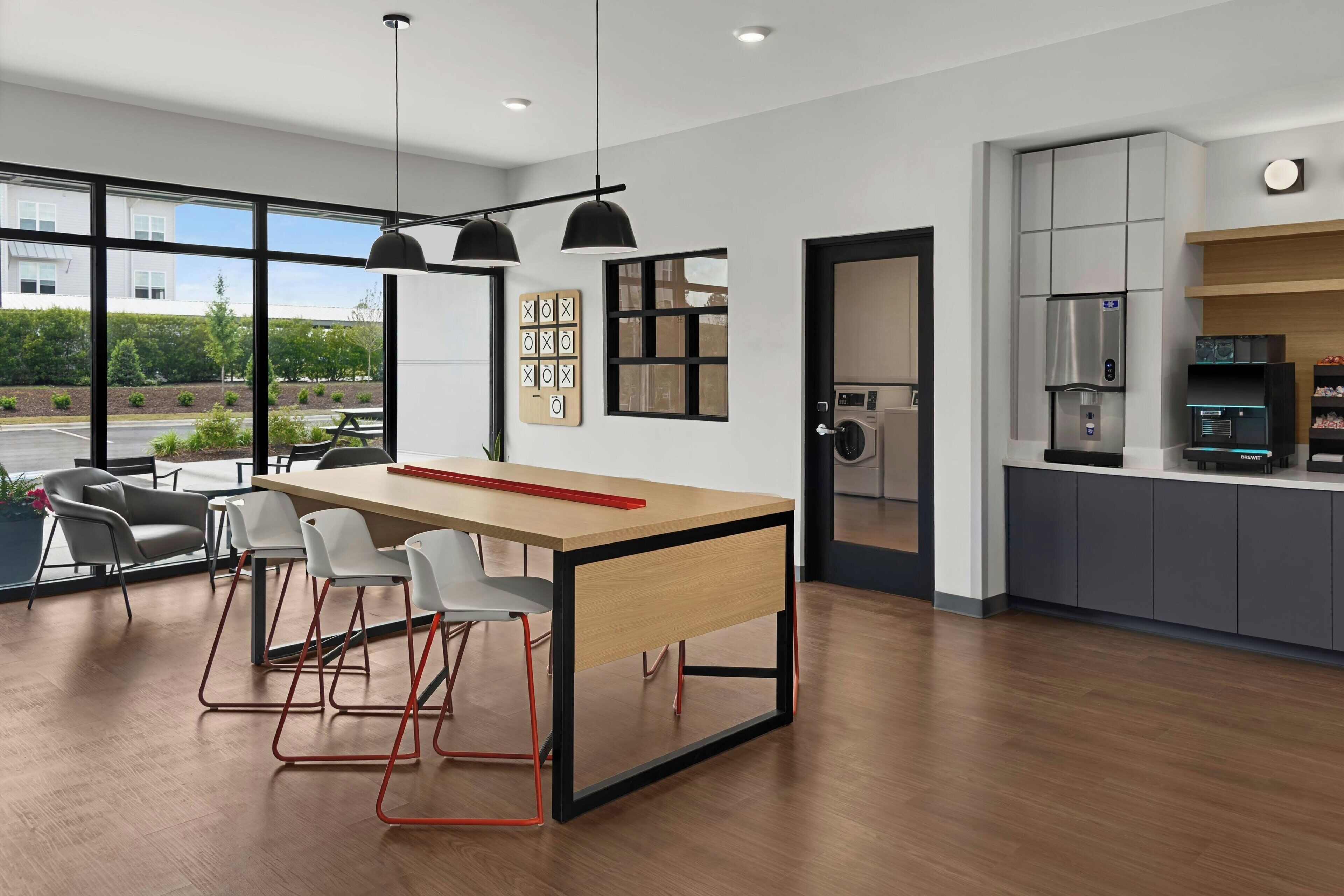A modern kitchen with a built-in oven, a coffee machine, and a refrigerator.