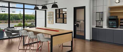 A modern kitchen with a built-in oven, a coffee machine, and a refrigerator.