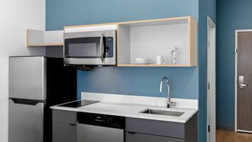 A modern kitchen with a built-in microwave, a dishwasher, and a sink.