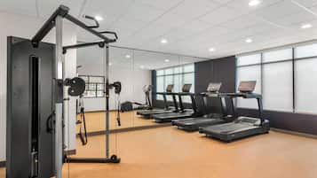 A gym with treadmills, a weight machine, and a mirror.