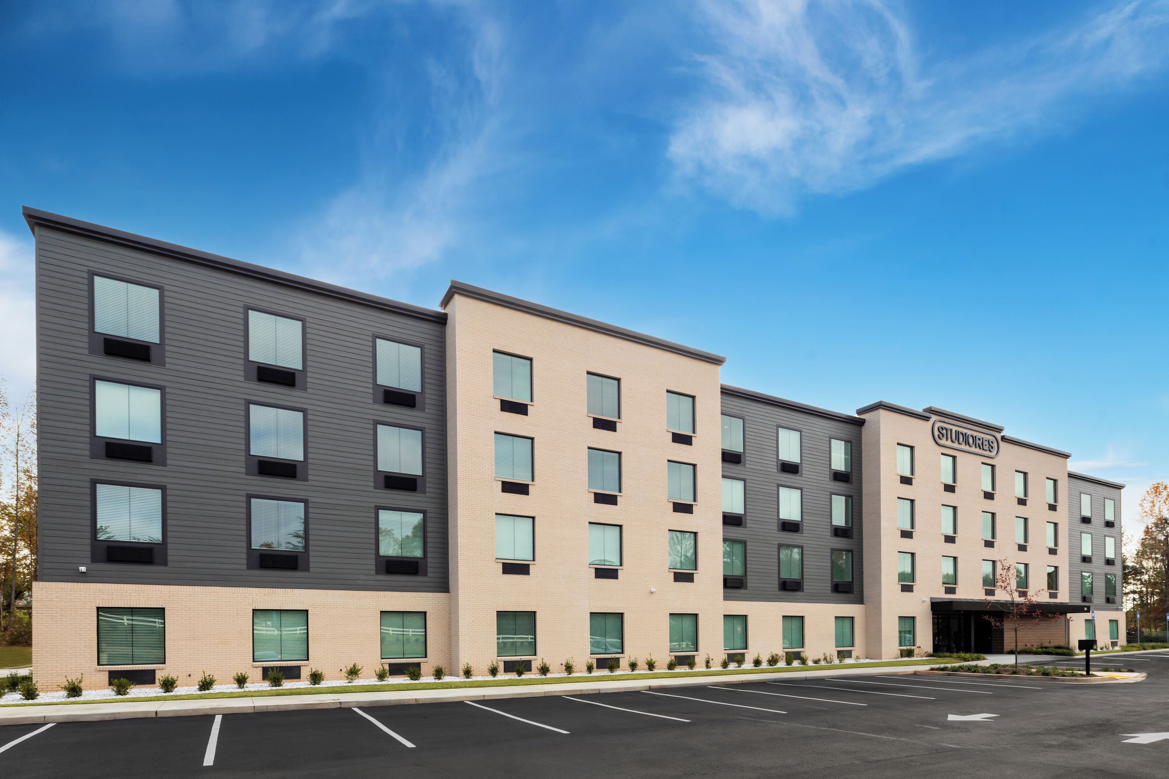 A multi-story hotel with a modern design, featuring a mix of window styles and a flat roof.