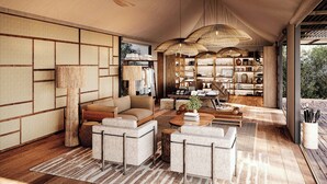 Amplia sala de estar con un conjunto de sofás, una mesa de centro y una estantería llena de libros y objetos decorativos.