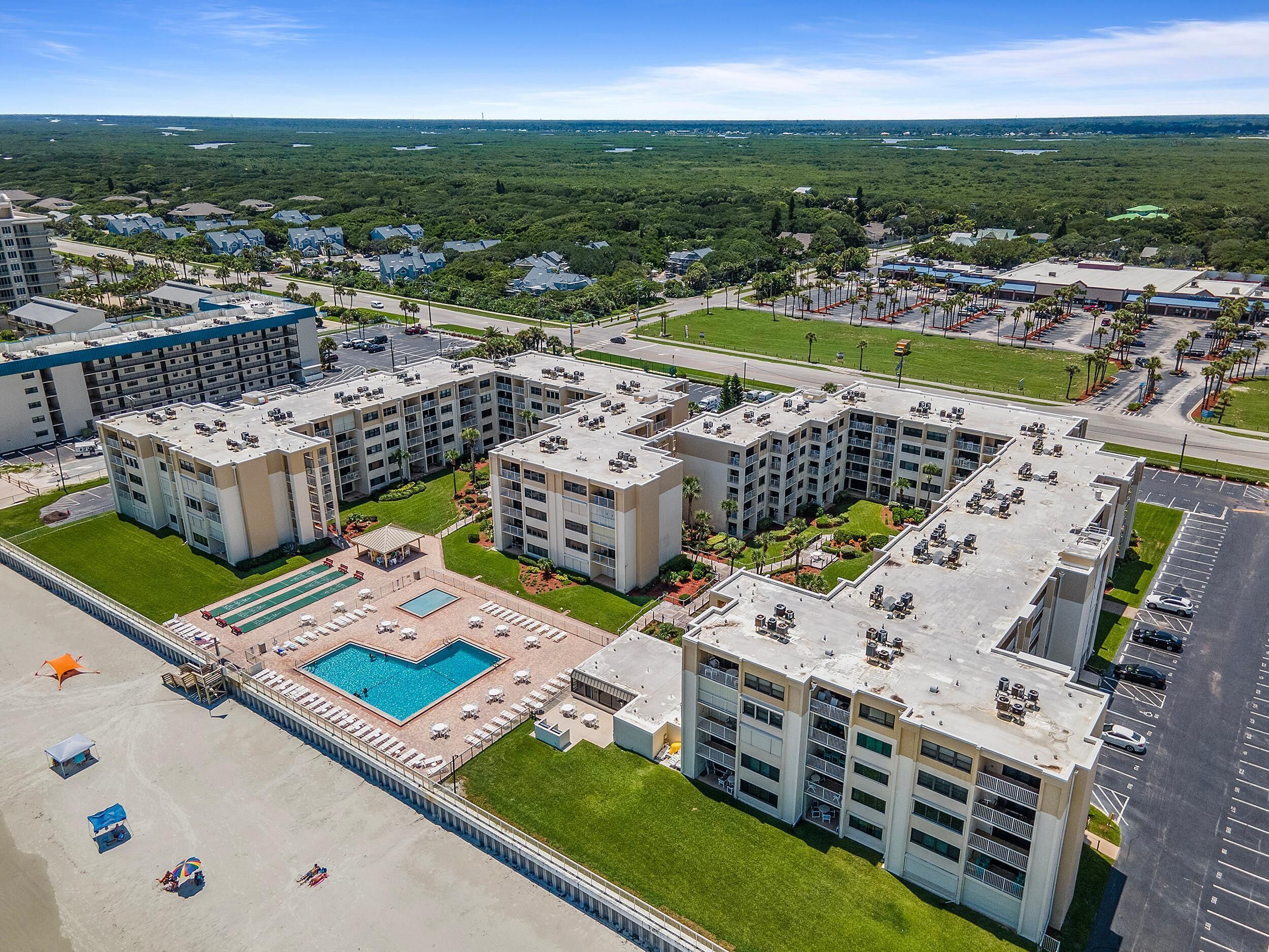 A multi-story hotel with a rooftop pool and a landscaped courtyard.