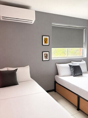 A modern bedroom with a bed, a window, and two framed pictures on the wall. - Adhoc Macro (Monterrey)