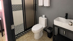A modern bathroom with a toilet, sink, and shower area. - Adhoc Macro (Monterrey)