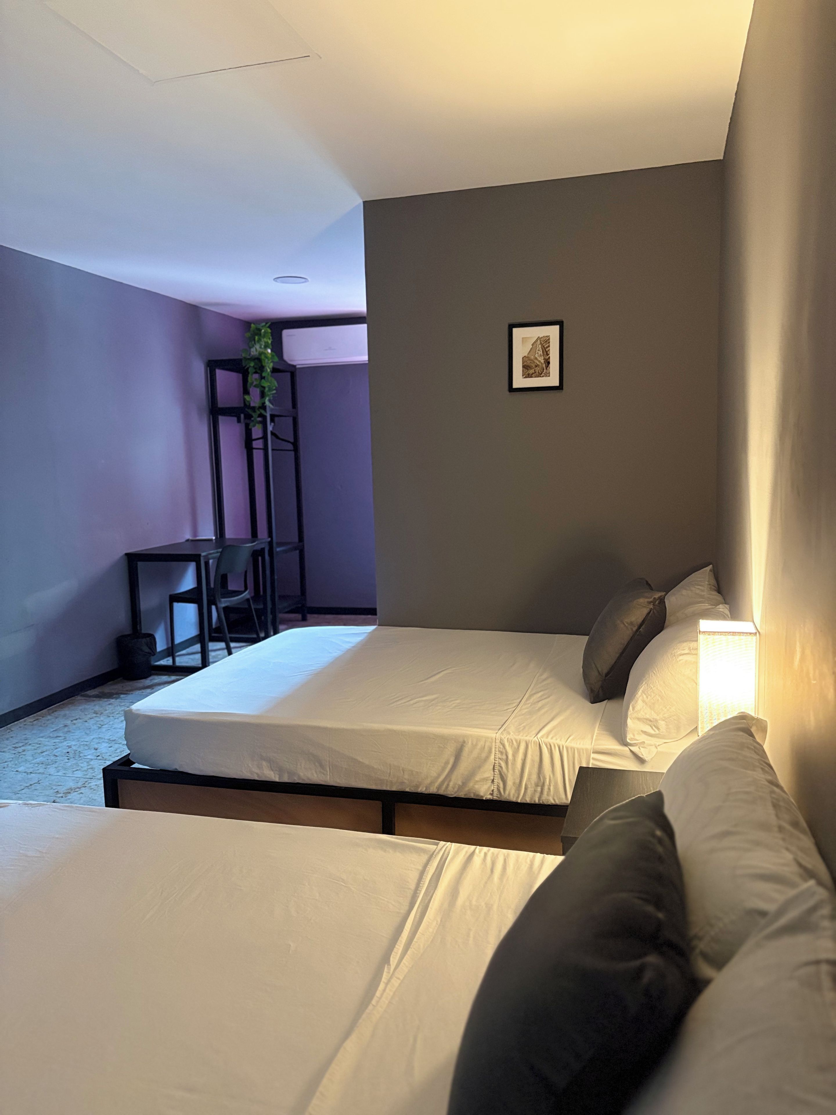 A hotel room with two beds, a desk, and a chair.