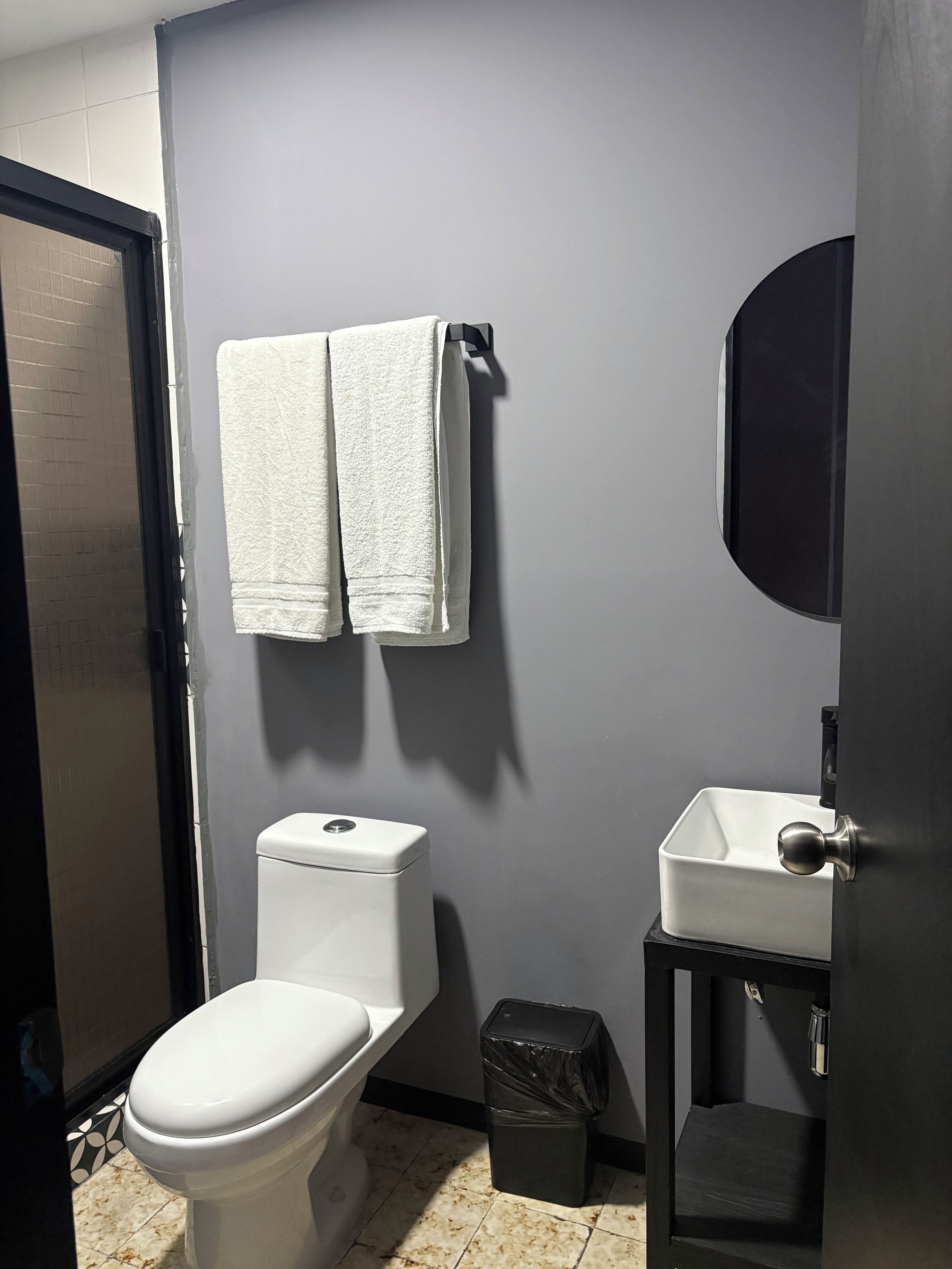 Une salle de bain équipée de toilettes, d’un lavabo et d’une poubelle.