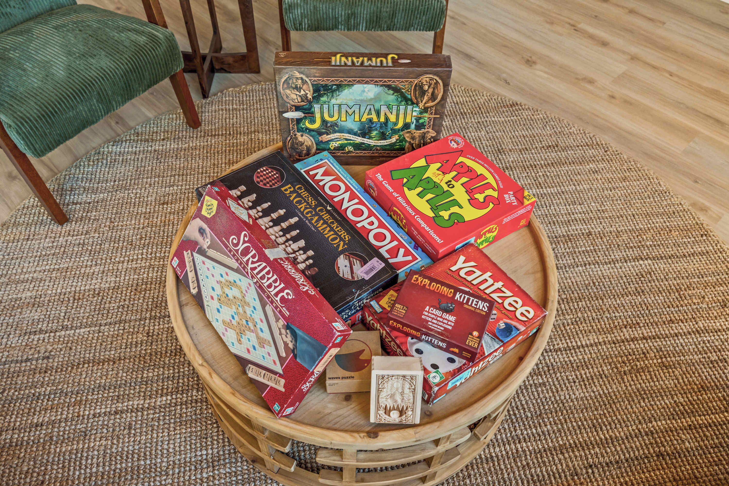 Un plateau en bois contenant divers jeux de société, notamment Monopoly, Jumanji et Yahtzee.