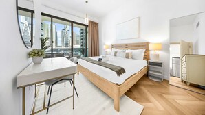 Een moderne hotelkamer met een groot bed, een bureau en uitzicht op de stad door grote ramen.
