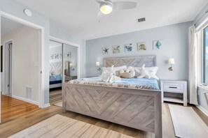 A bedroom with a bed, bedside tables, a ceiling fan, and wall art. - Professionally Managed | Walk to Beach (Seaside Heights)