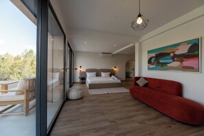 A modern bedroom with a large bed, a red sofa, a glass wall, and a painting on the wall. - Villa Adam Luxe Marrakech, 5 Suites, Large Private Pool, sleeps 11 (Marrakech)