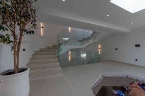 A modern interior with a staircase, a potted plant, and a toy collection. - Villa Adam Luxe Marrakech, 5 Suites, Large Private Pool, sleeps 11 (Marrakech)