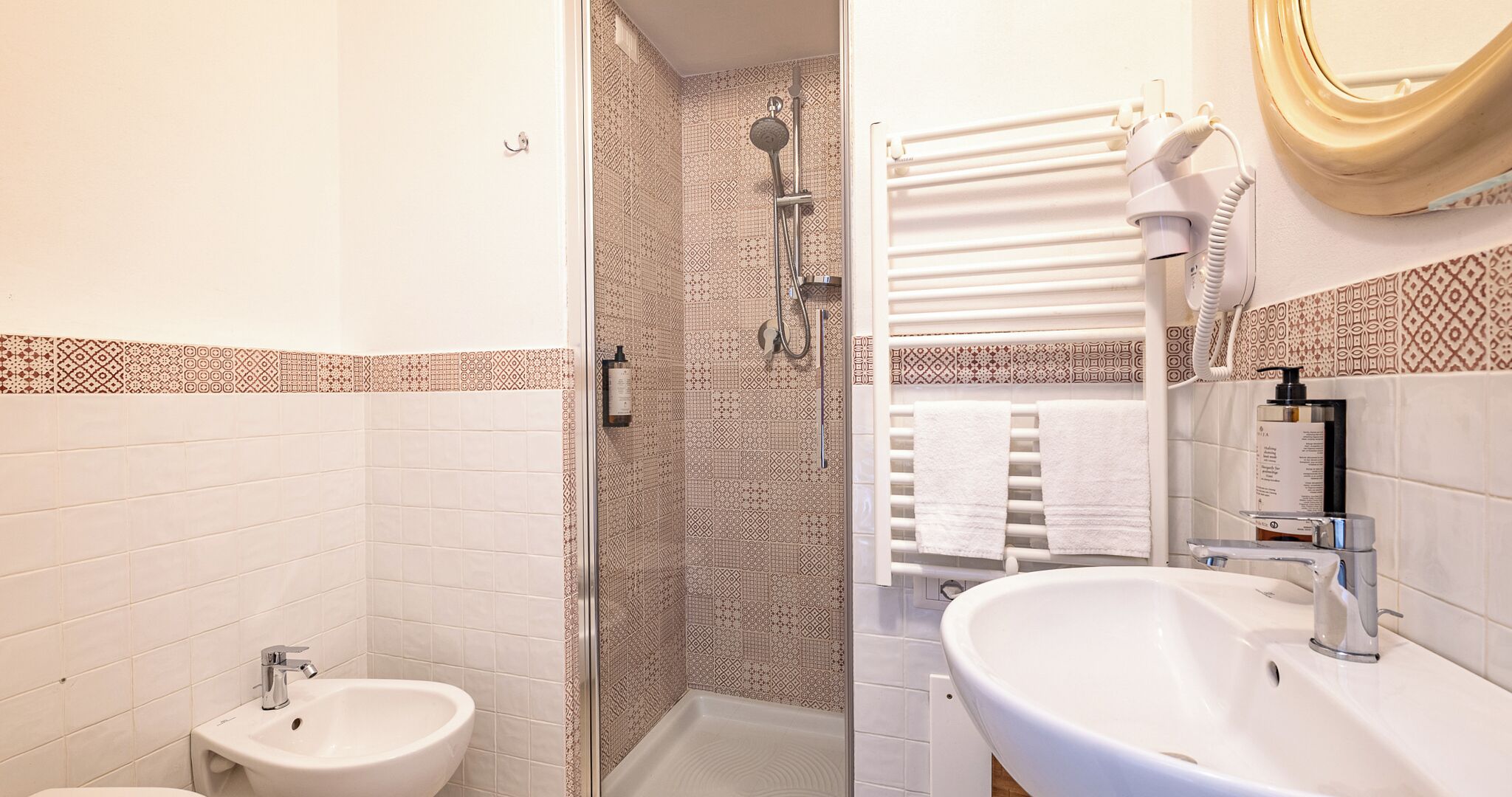 A bathroom with a shower, a sink, and a toilet.