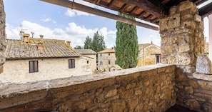 A stone balcony overlooking traditional buildings with tiled roofs and a clear sky. - Locanda Casalta (Strove)